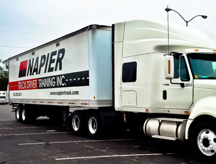 Image of a white Napier truck parked in the CDL training parking lot.