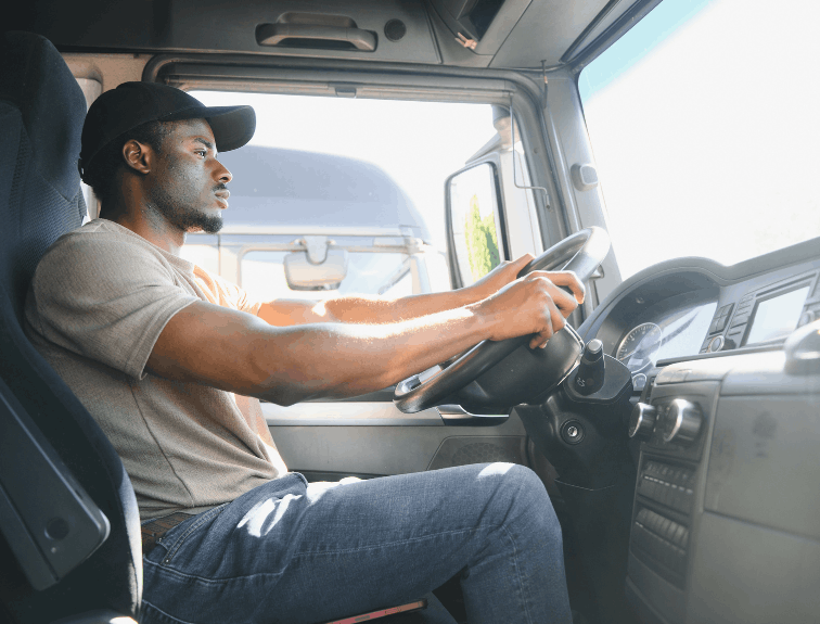 Truck driver sitting behind wheel, photo taken from passenger seat