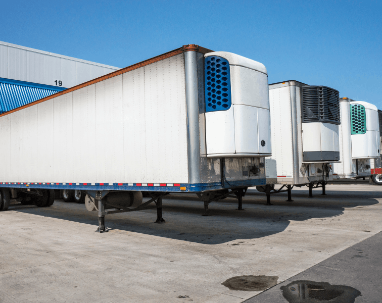 Three refrigerated trailers parked in warehouse