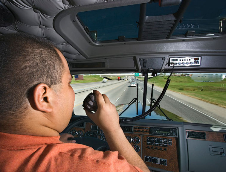 Trucker sitting in driver seat, talking on intercom