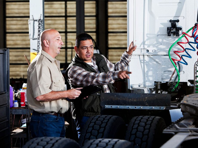 Image of a CDL instructor and student looking at the parts of a truck