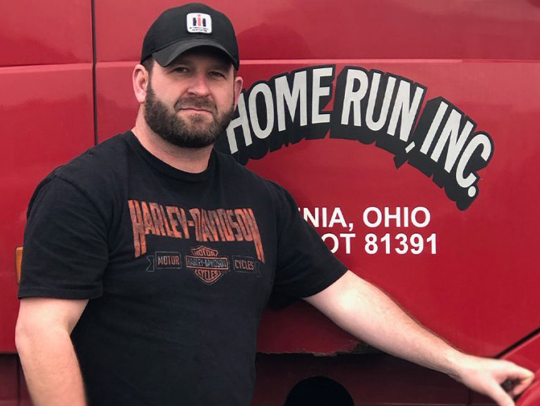 Image of Dallas Young, former Napier student in front of red Home Run, Inc. truck